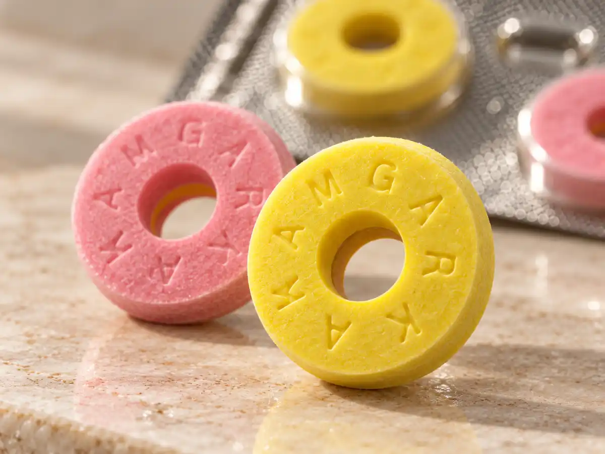 Kamagra bombone 100 mg – macro prikaz žute i roze tablete za žvakanje
